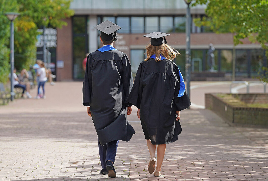 Two alumni walking on campus