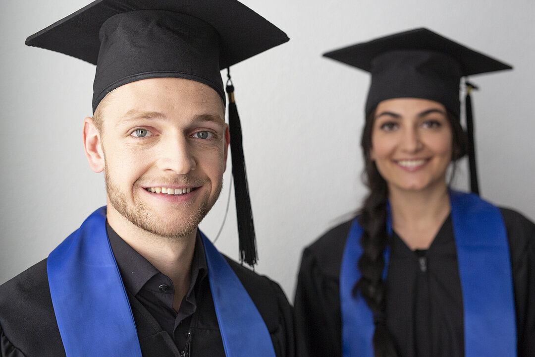 Zwei Alumni mit schwarzer Robe